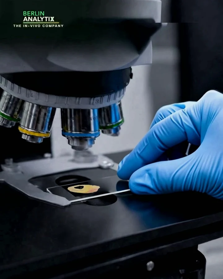 Cinematic view of a gloved hand and microscope stage.